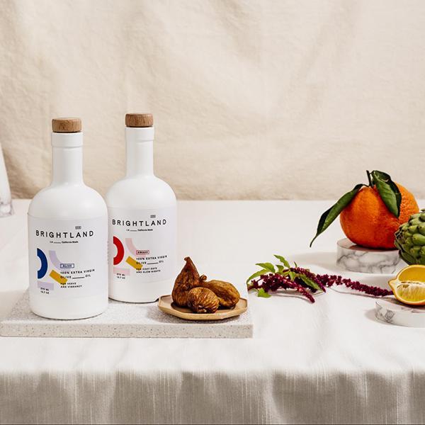 a pair of brightlands alive and awake oils on display with various fruits and vegetables