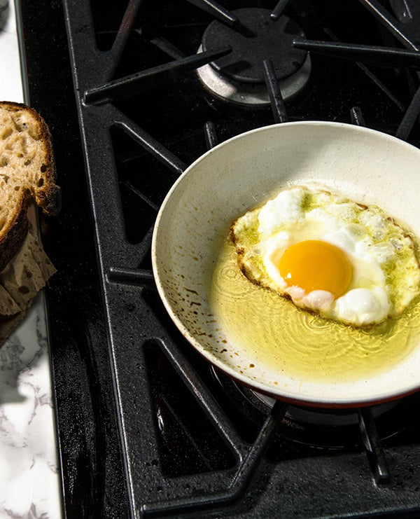a person frying an egg in oil