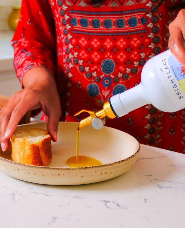 pouring brightland oil onto bread