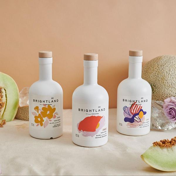an assortment of brightland oils on a table with melons